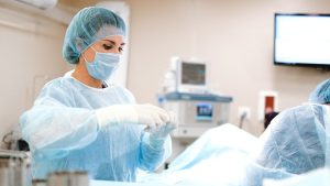 Woman in Blue Dress Shirt Wearing Blue Mask and White Latex Gloves | Breast Cancer Car Donations