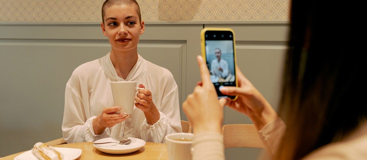 Woman in White Long Sleeve Shirt Holding Cuo | Breast Cancer Car Donations