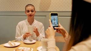 Woman in White Long Sleeve Shirt Holding Cuo | Breast Cancer Car Donations