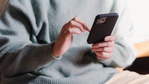 Woman surfing internet with mobile phone | Breast Cancer Car Donations