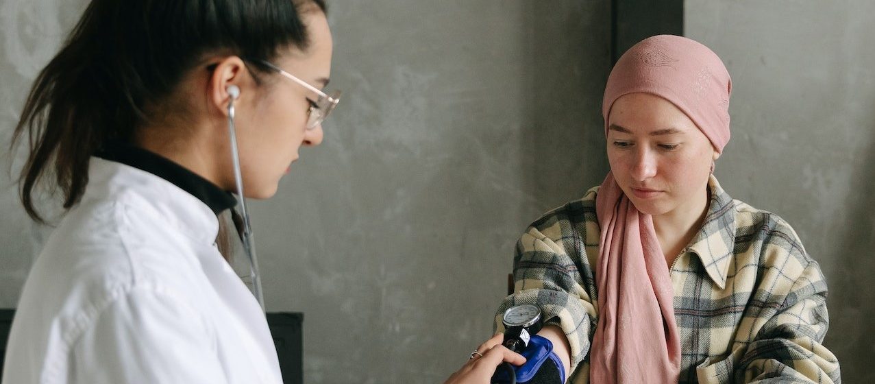 A Man Checking a Woman's Blood Pressure | Breast Cancer Car Donations