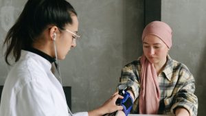 A Man Checking a Woman's Blood Pressure | Breast Cancer Car Donations