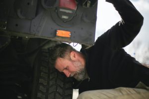 Person Checking Car Tire Pressure | Breast Cancer Car Donations
