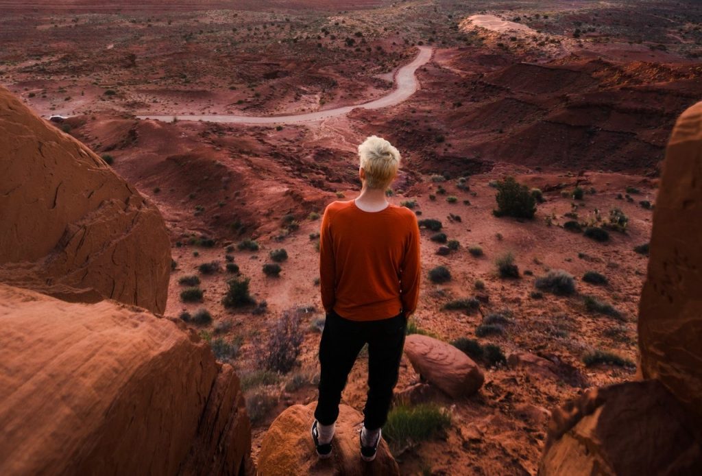 Person Standing at a Rock Formation in a National Park | Breast Cancer Car Donations