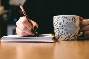 Woman Writing in a Notebook | Breast Cancer Car Donations