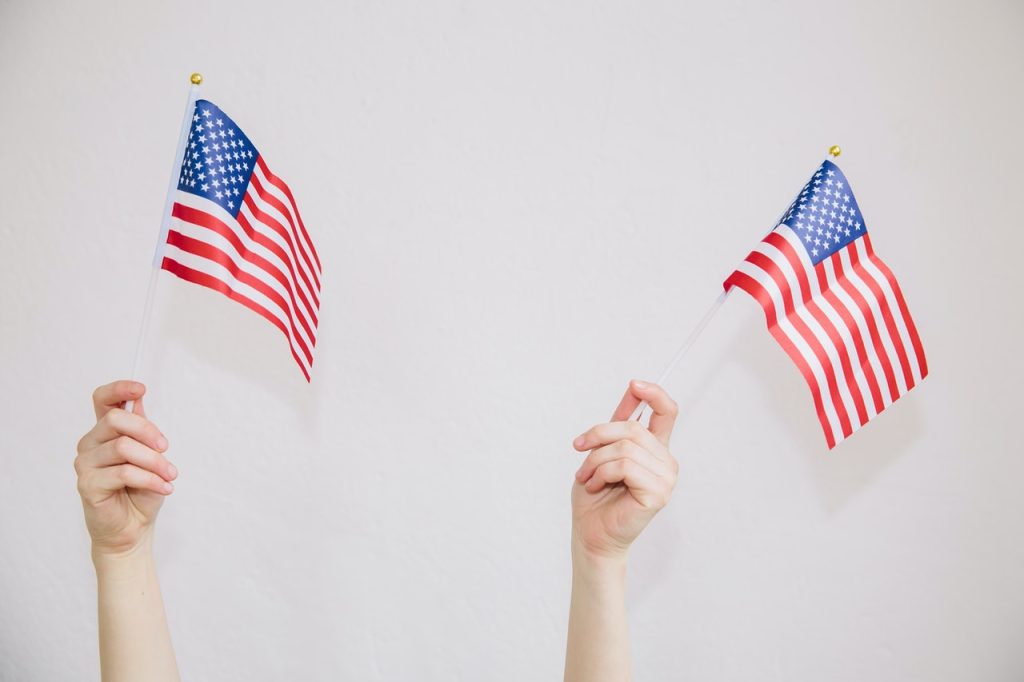 Hands Waving US Flag | Breast Cancer Car Donations