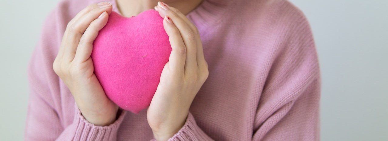 woman with pink heart in hands | Breast Cancer Car Donations