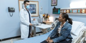 Woman in Blue Denim Jacket Sitting on Hospital Bed | Breast Cancer Car Donations