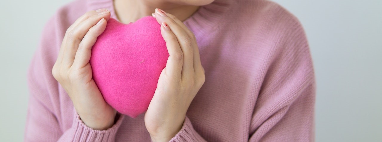 woman with pink heart in hands. | v