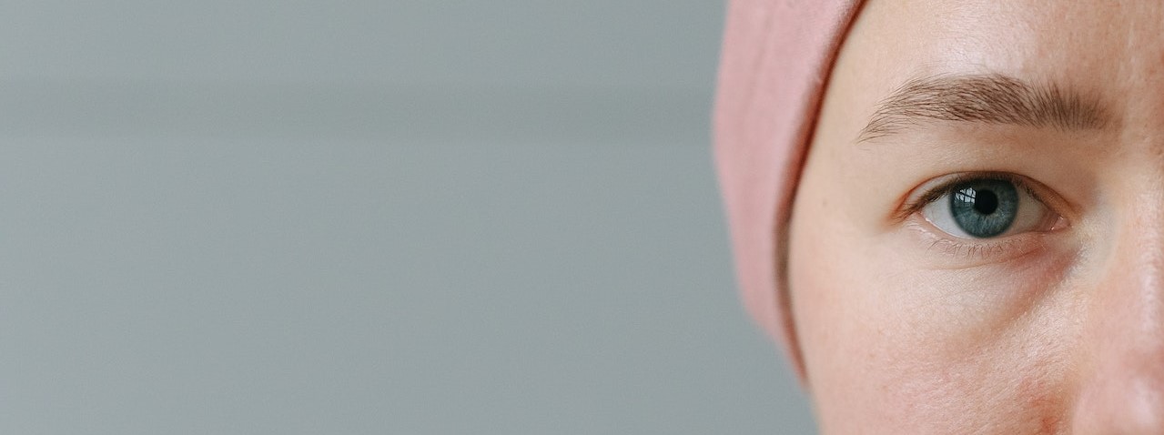 Half Face of a Woman Wearing Pink Bonnet | Breast Cancer Car Donations 