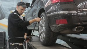 Car Mechanic Pumping Up Car with Air | Breast Cancer Car Donations