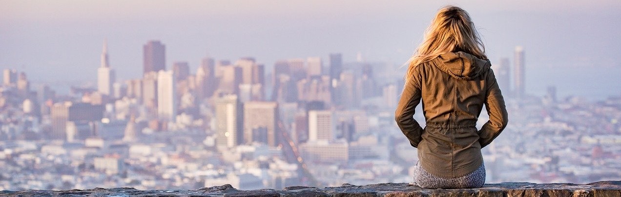 Woman Sitting Alone Looking at the Buildings | Breast Cancer Car Donations