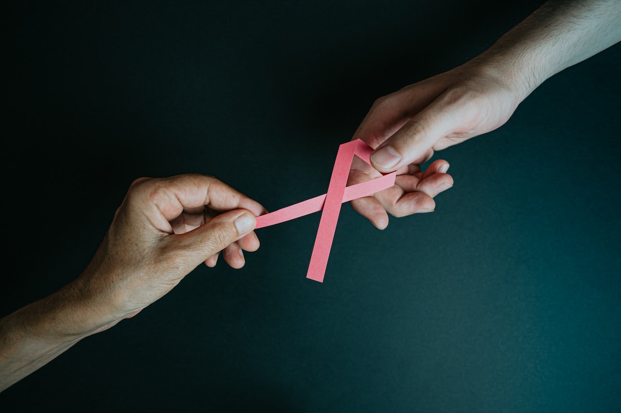Hands Holding Breast Cancer Pink Paper Ribbon (2) | Breast Cancer Car Donations