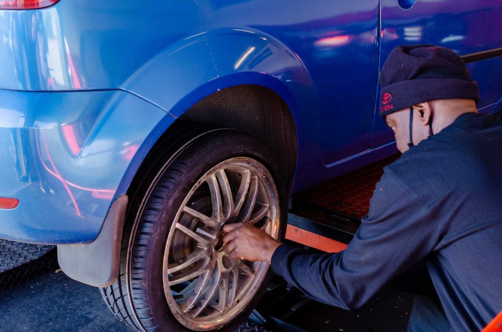 Man Changing Car Tire | Breast Cancer Car Donations