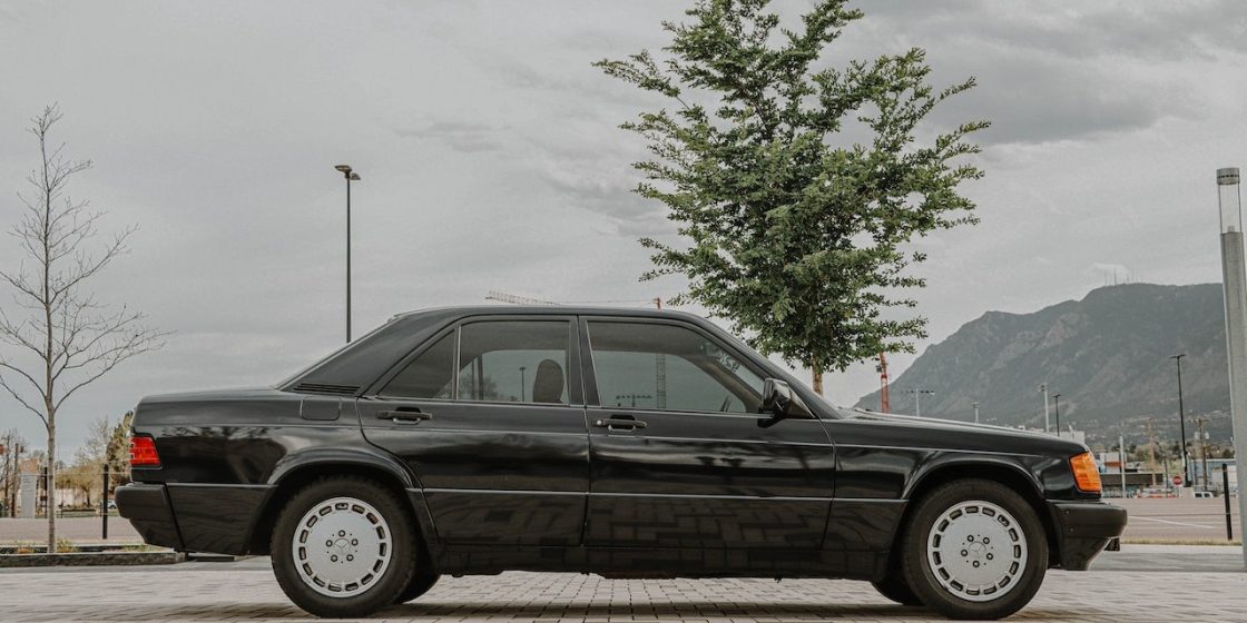 Black Classic Car Parked Beside Green Tree | Breast Cancer Car Donations