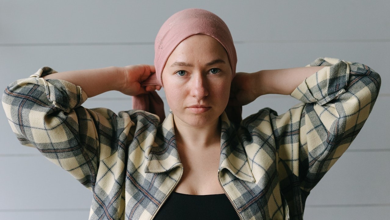 Woman Tying Her Pink Headwrap | Breast Cancer Car Donations