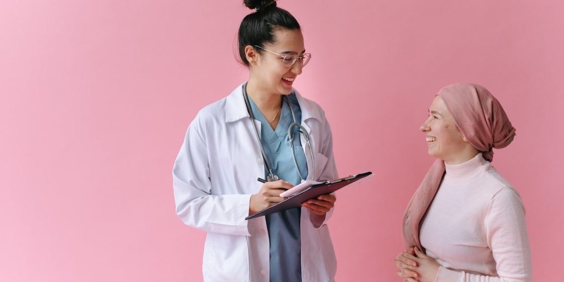 Woman in White Robe Holding Tablet Computer | Breast Cancer Car Donations