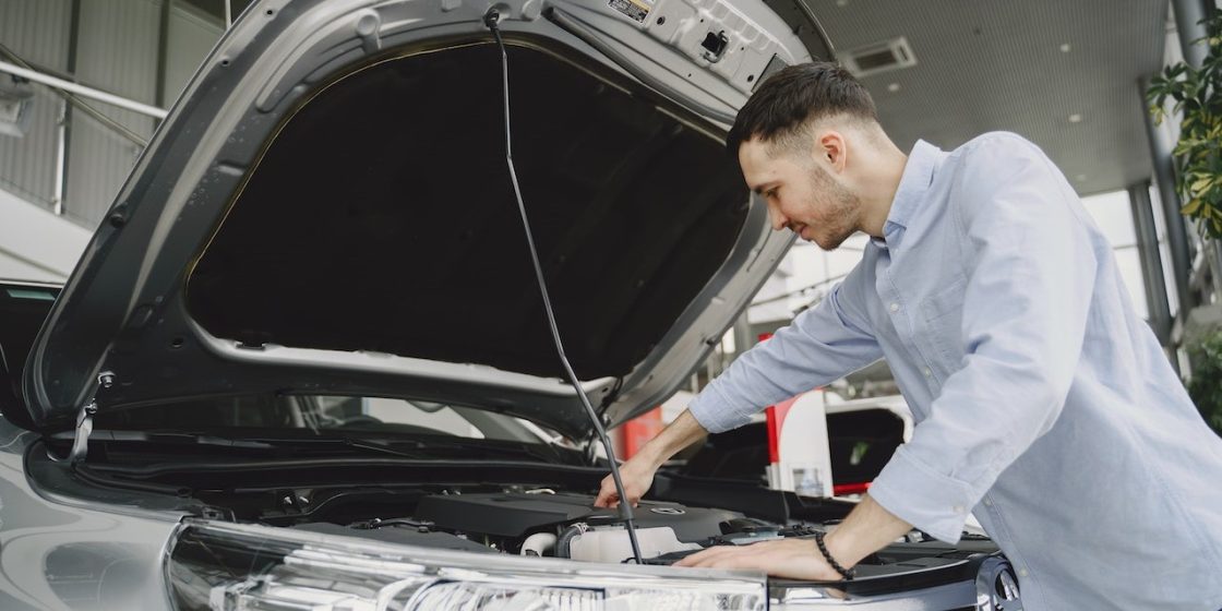 Man Checking the Engine of a Car | Breast Cancer Car Donations