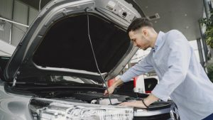 Man Checking the Engine of a Car | Breast Cancer Car Donations