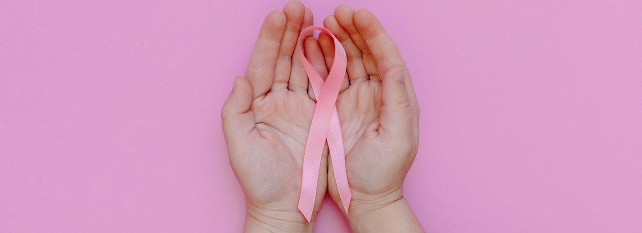 A Person Holding a Pink Ribbon | Breast Cancer Car Donations
