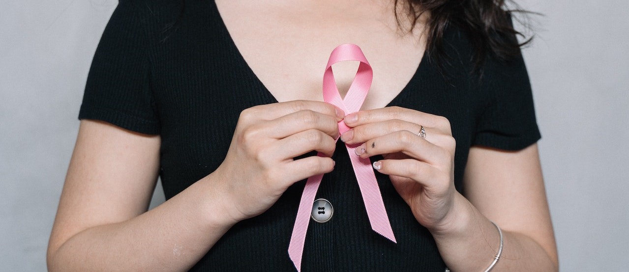 Woman Holding Pink Ribbon | Breast Cancer Car Donations