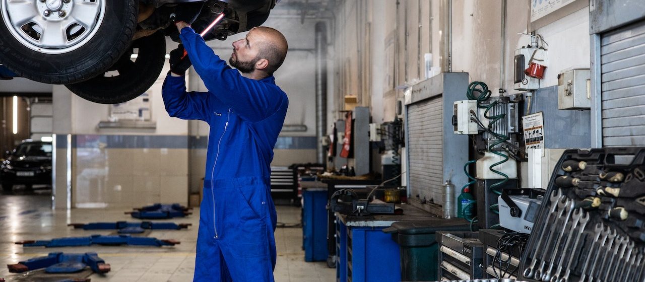 A Man in Blue Suit Checking a Car | Breast Cancer Car Donations