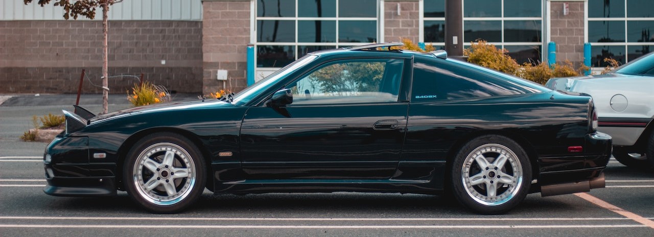 Modern black car parked on edge of road | Breast Cancer Car Donations