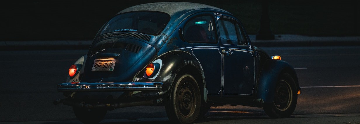 A Black Volkswagen Beetle Parked on the Road at Night | Breast Cancer Car Donations