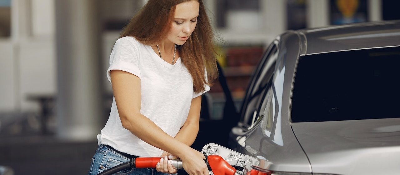 Focused young woman refueling car | Breast Cancer Car Donations