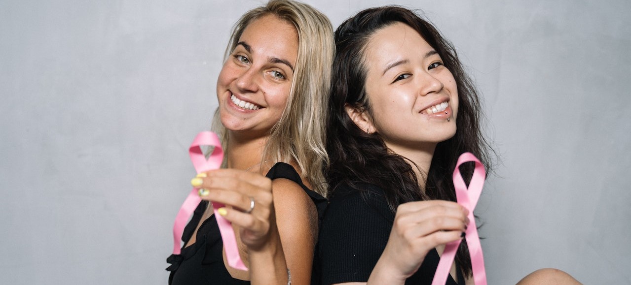 2 Women in Black Tank Top Holding Pink Ribbon | Breast Cancer Car Donations