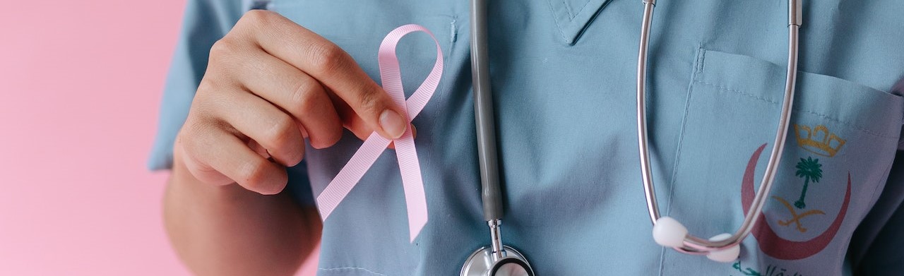A Doctor Holding a Pink Ribbon | Breast Cancer Car Donations