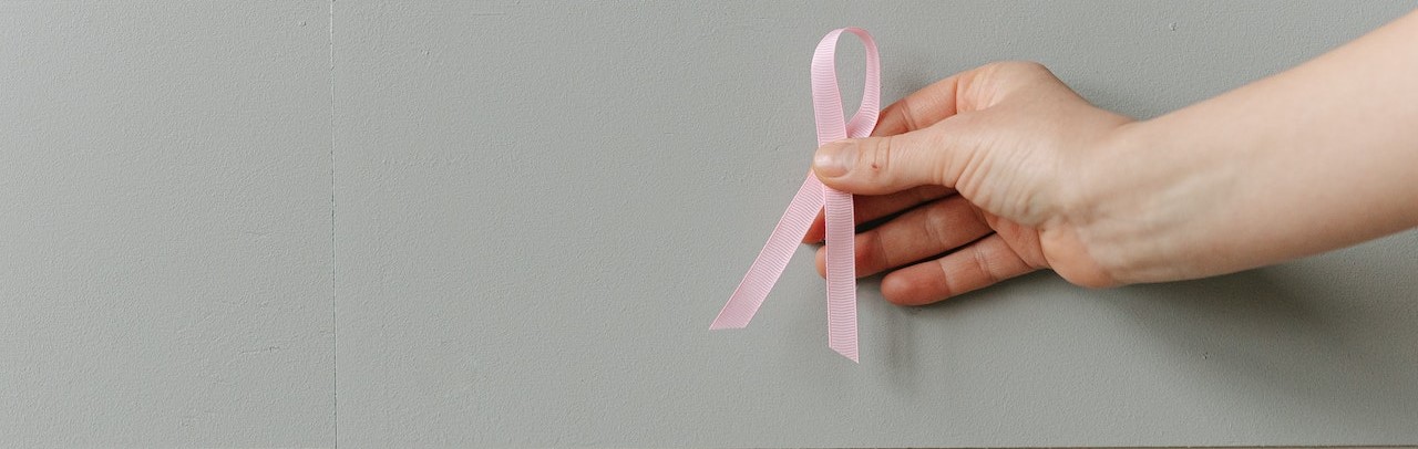 A Person Holding a Pink Ribbon | Breast Cancer Car Donations