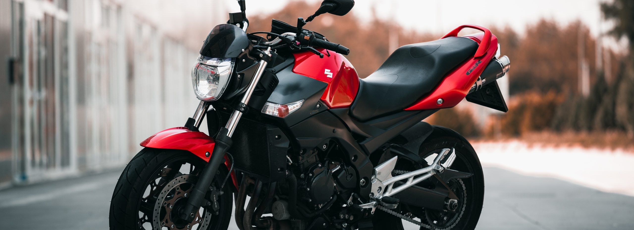 A Red and Black Suzuki Motorcycle Parked on the Street | Breast Cancer Car Donations