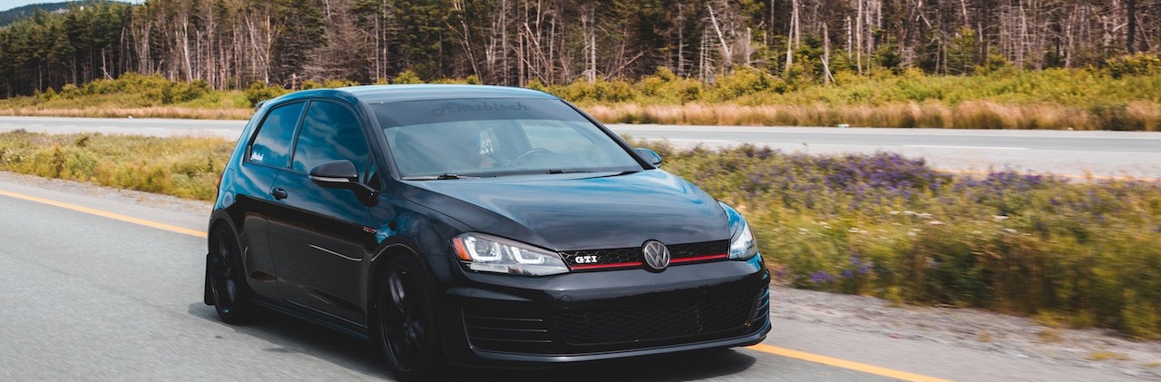 Black sports car on highway | Breast Cancer Car Donations