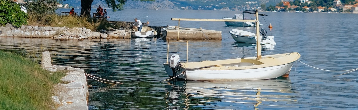 Boat tied on dock in a lake | Breast Cancer Car Donations