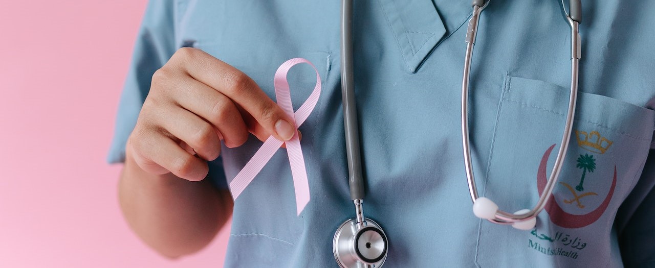 Doctor holding a pink ribbon | Breast Cancer Car Donations