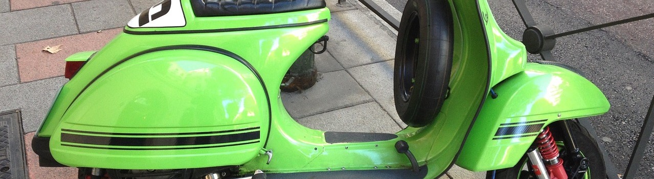 Green scooter parked on the side of the street | Breast Cancer Car Donations