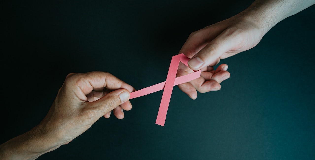 Hands Holding Breast Cancer Pink Paper Ribbon | Breast Cancer Car Donations