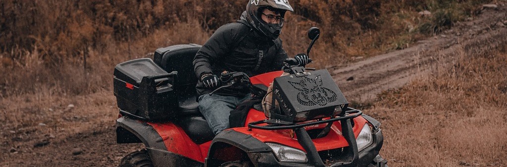 Man riding a black atv | Breast Cancer Car Donations