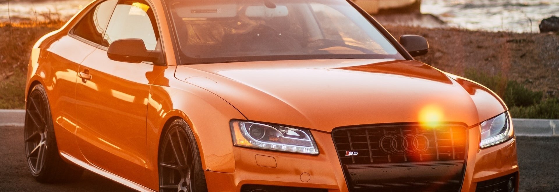 Orange Audi Coupe parked on a gray concrete | Breast Cancer Car Donations