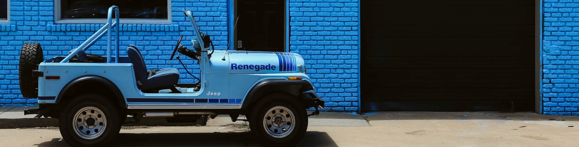 Parked jeep near a blue wall | Breast Cancer Car Donations