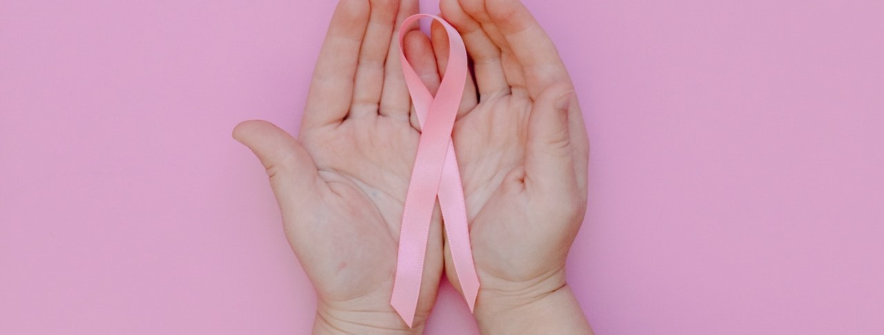 Person Holding Pink Ribbon | Breast Cancer Car Donations