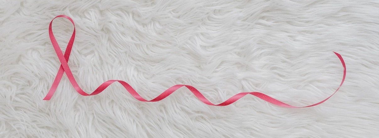 Pink ribbon on furry floormat | Breast Cancer Car Donations