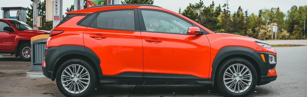 Red SUV parked on gasoline station | Breast Cancer Car Donations