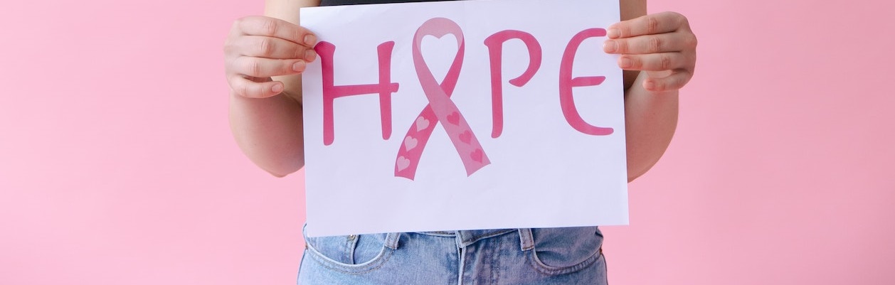 Sad woman holding pink ribbon | Breast Cancer Car Donations
