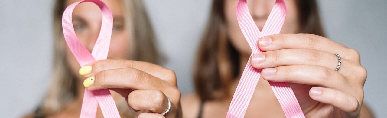 Two woman holding a pink ribbon | Breast Cancer Car Donations
