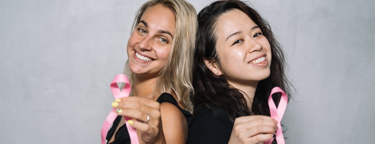 Two woman holding pink ribbon | Breast Cancer Car Donations
