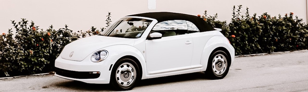 White Convertible Coupe Parked Beside House | Breast Cancer Car Donations