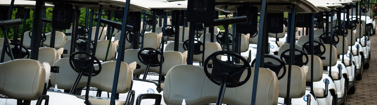 White Golf Carts Parked in line | Breast Cancer Car Donations