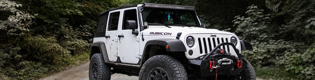 White Jeep Wrangler on Asphalt Road | Breast Cancer Car Donations